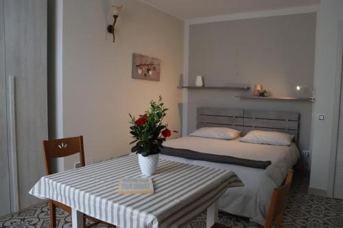 Un dormitorio con una cama y una mesa con un jarrón de flores en Casa Santa Caterina en Massafra