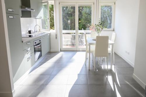 a kitchen with white appliances and a table with chairs at Roma Aurelio appartamento con piscina in Rome