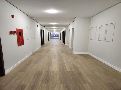 a long hallway with white walls and wooden floors at HOTEL CAMPO GRANDE in Campo Grande