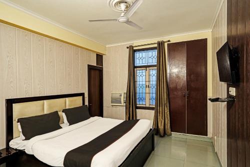 een slaapkamer met een groot bed en een raam bij Capital O Bk House in Noida