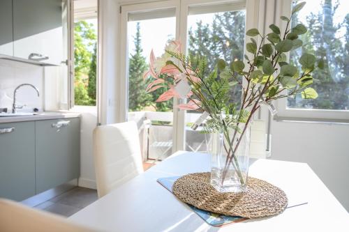 a vase of flowers on a table in a kitchen at Roma Aurelio appartamento con piscina in Rome