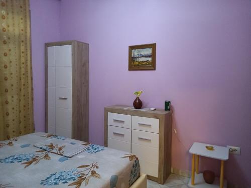 Schlafzimmer mit einem Bett, einer Kommode und einem Spiegel in der Unterkunft Orkiton House in Durrës