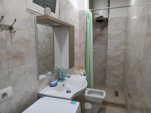 y baño con lavabo, aseo y espejo. en Orkiton House en Durrës