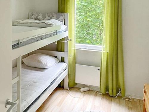 Holiday home UDDEVALLA XL في Sundsandvik: غرفة نوم بسريرين بطابقين ونافذة