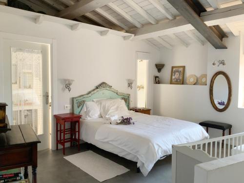 Dormitorio blanco con cama y mesa en La Grulla Dorada, en Perales del Puerto