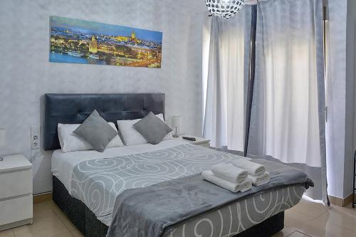 a bedroom with a bed with towels on it at Apartamento Muralla in Seville