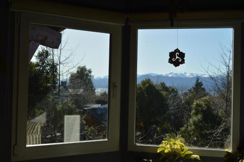 2 ventanas con vistas a las montañas en Cabaña Los Ulmos Bariloche en San Carlos de Bariloche