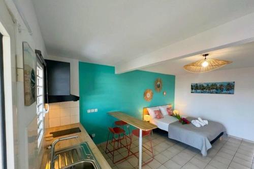 um quarto com uma cama e uma cozinha com um lavatório em Appartement les pieds dans l'eau em Sainte-Anne