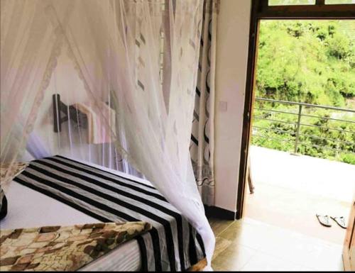 a bedroom with a bed and a window with a view at Rawana Mountain View in Ella