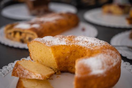 a piece of cake on a plate with powdered sugar at Hotel Monte44 in Selva di Val Gardena