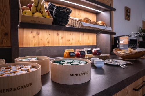 a counter with three containers of food on a counter top at Hotel Monte44 in Selva di Val Gardena