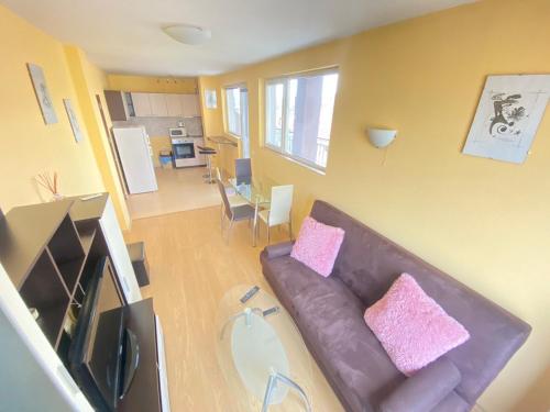 - un salon avec un canapé brun et des oreillers roses dans l'établissement Holidays apartment Bourgas, à Bourgas