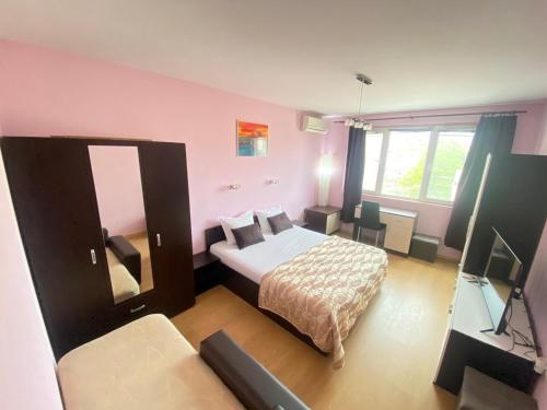 - une petite chambre avec un lit et une télévision dans l'établissement Holidays apartment Bourgas, à Bourgas