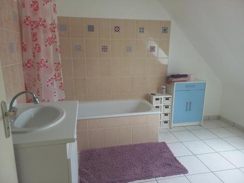 une petite salle de bain avec une baignoire et un lavabo dans l'établissement Binic 700m de la plage 4 chambres, jardin, linge, wifi, à Binic