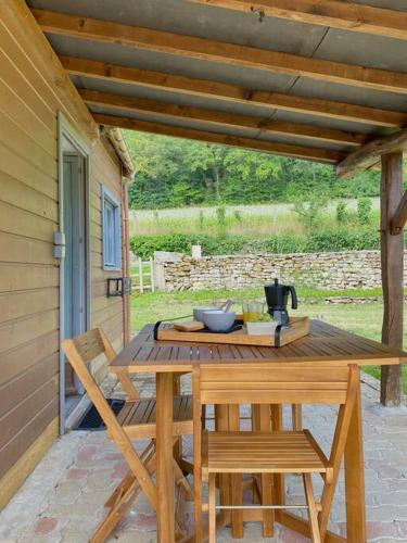 - une table en bois et 2 chaises sur la terrasse dans l'établissement Petite maison dans la prairie, à Marmeaux