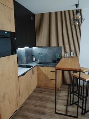 a kitchen with a sink and a table in it at Apartament Kozigród in Tczew