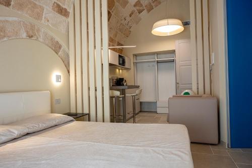 a bedroom with a bed and a room with a kitchen at Iris apartments in Monopoli