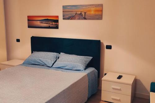 a bedroom with a bed and two pictures on the wall at mono polis apartment in Monopoli