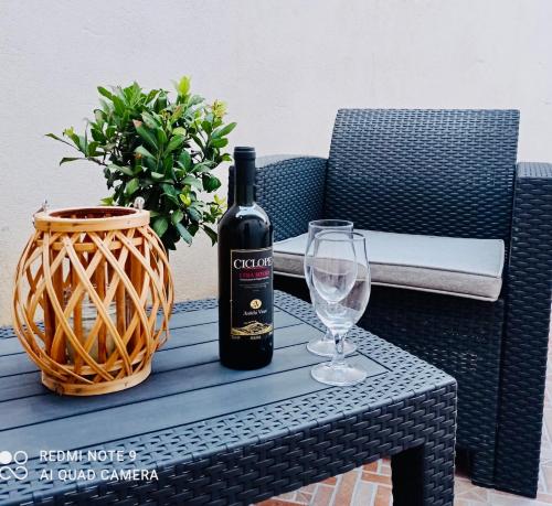 una botella de vino sentada en una mesa con una copa en Vacanze siciliane, en Fiumefreddo di Sicilia