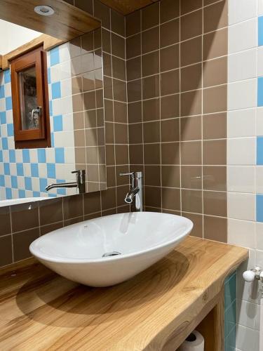 uma casa de banho com um lavatório branco num balcão de madeira em Il sette e l'otto em Caiazzo