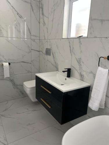 a white bathroom with a sink and a toilet at Villa Le Rosa Unit 3 in Durban