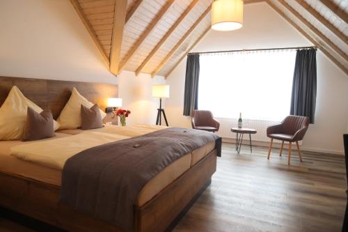 a bedroom with a large bed and a large window at Hotel Stremme in Gummersbach