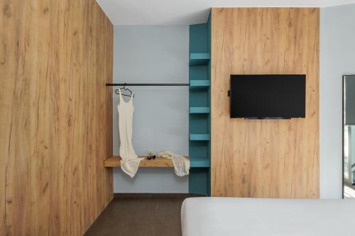 a bedroom with a tv on a wall and a bed at THE URBANIST •inner city residences• in Ioannina