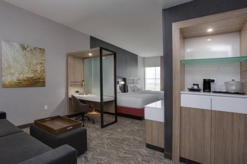 a hotel room with a bed and a living room at SpringHill Suites by Marriott Fort Lauderdale Miramar in Miramar