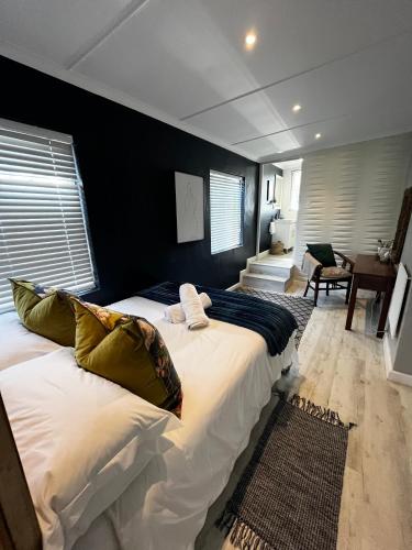 a large bed in a bedroom with a black wall at Seven on Flora- Hot Tub, Modern with amazing outside area in Hermanus