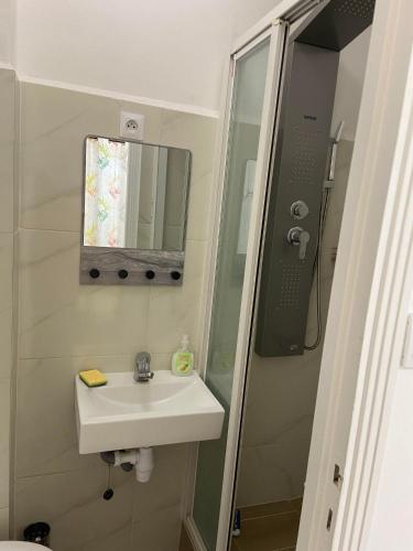 a bathroom with a sink and a shower with a mirror at Chambres n°4 (1-2pers) + Balcon in Prayssac