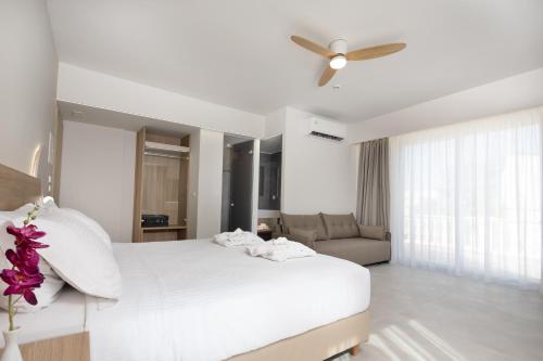 a bedroom with a white bed and a ceiling fan at Epavli Grace Hotel in Chania Town