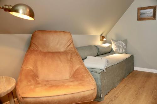 a living room with a couch and a chair at HaffSide Usedom in Zirchow