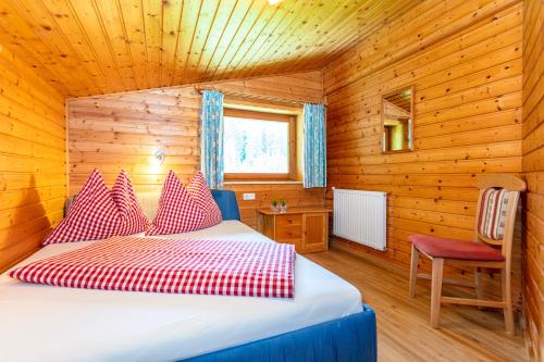 ein Schlafzimmer mit einem Bett in einer Holzhütte in der Unterkunft Obertaxinghof in Saalbach-Hinterglemm
