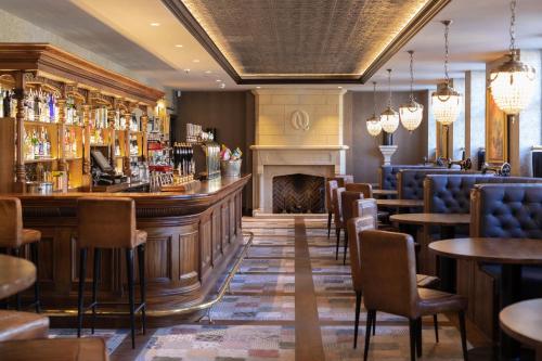 a bar with a fireplace and tables and chairs at The Queens Head, Parkside Apartment 4 in Burley in Wharfedale