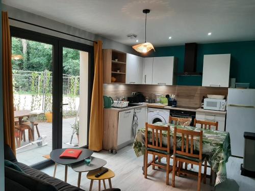 une cuisine et un salon avec une table et une salle à manger dans l'établissement Lisière de la Forêt, à La Baule