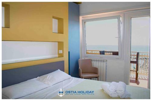 Un dormitorio con una cama y una ventana con vistas. en Ostia Holiday Sunset, en Lido di Ostia