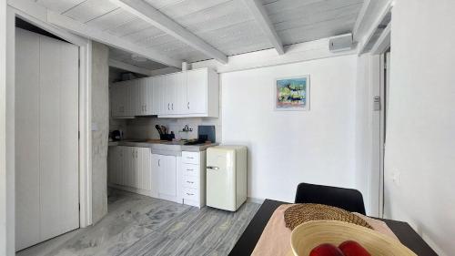 a kitchen with white cabinets and a refrigerator in a room at Ricardo by the sea in Parikia