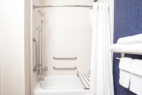 uma casa de banho com um chuveiro e uma banheira branca em Fairfield Inn by Marriott North Little Rock em North Little Rock