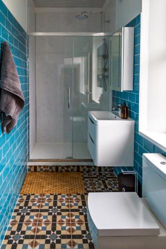 a bathroom with a shower and a toilet and a sink at Spacious Cottage with Private Hot Tub in Baildon