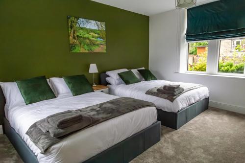 - 2 lits dans une chambre dotée de murs verts et de fenêtres dans l'établissement Detached Luxury 6 beds, Super Wi-fi, easy parking and Hot-tub, à Baildon