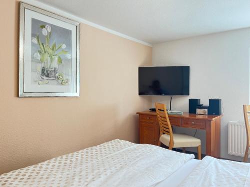 a bedroom with a bed and a desk with a television at Appartement Am Straßland in Kirchheim