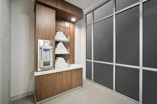 SpringHill Suites by Marriott Phoenix Goodyear في غوديير: غرفة مع موزع للمشروبات على الحائط
