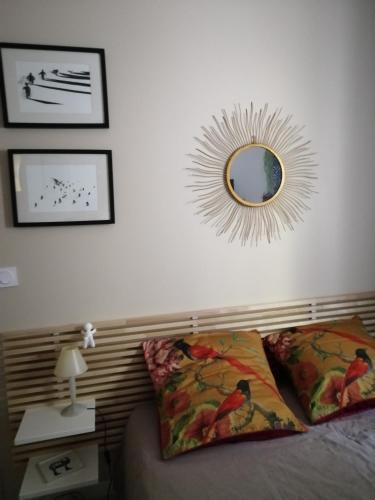 1 dormitorio con cama y espejo en la pared en Maison d'Art' lette en Saint-Féliu-dʼAvall