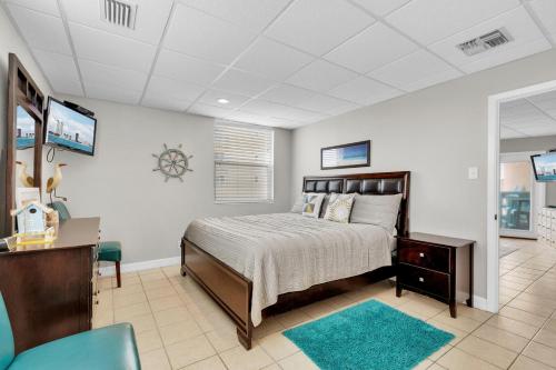 a bedroom with a bed and a desk and a tv at Bayfront condo with water view & boat slips! in South Padre Island