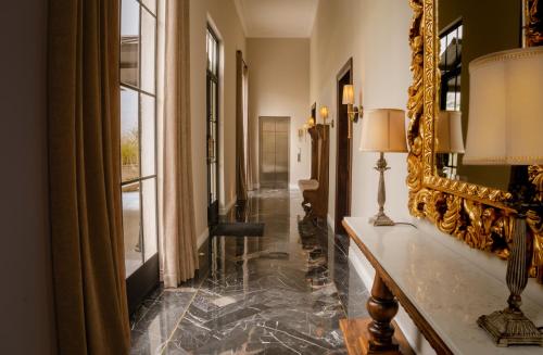 a hallway with a mirror and a marble floor at Hotel Plaza 79 in San Cristóbal de Las Casas