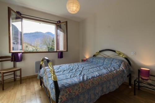 a bedroom with a bed and a large window at La Résidence de Lorelei in Cierp