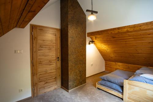 sypialnia z łóżkiem i drewnianą ścianą w obiekcie Horská Chata Čeladná w mieście Czeladna