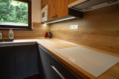 a kitchen with a wooden counter top and a window at Horská Chata Čeladná in Čeladná