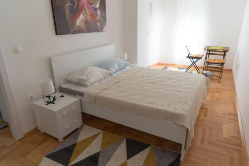 1 dormitorio con 1 cama, mesa y sillas en ZOJA Apartments #2, en Kavadarci