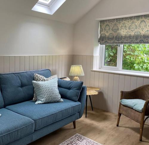 a blue couch in a living room with a window at Hillview Cottage in Edinburgh